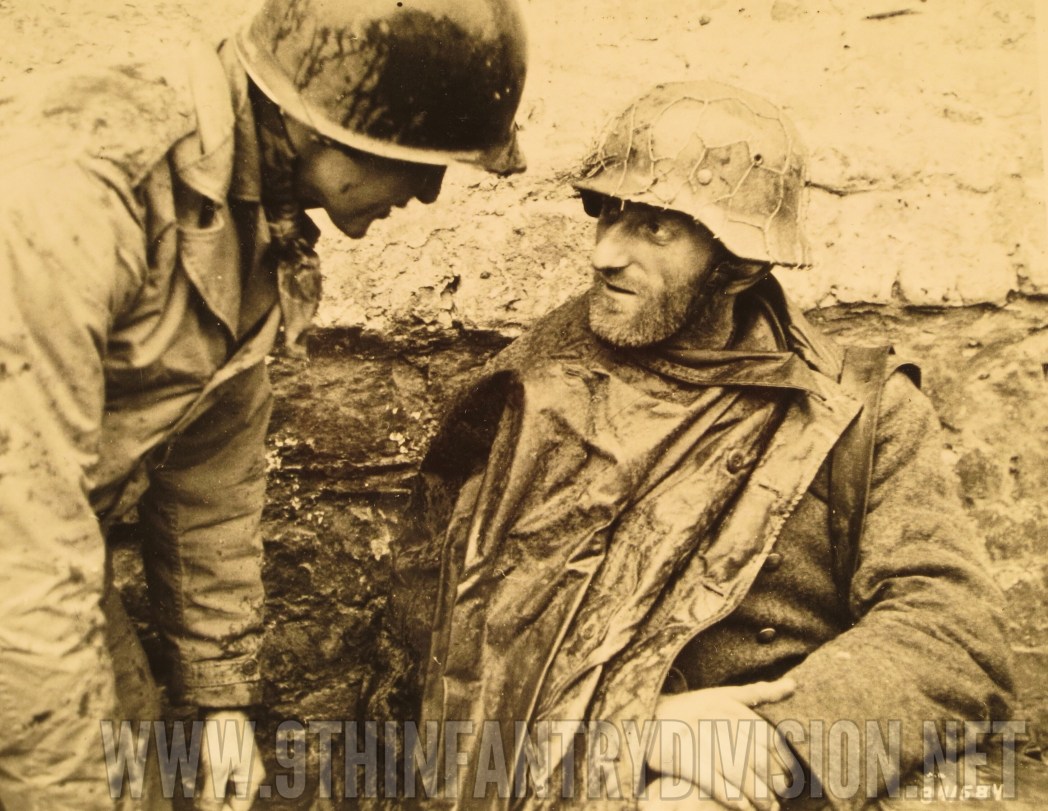 An American soldier talks to one of the German prisoners.