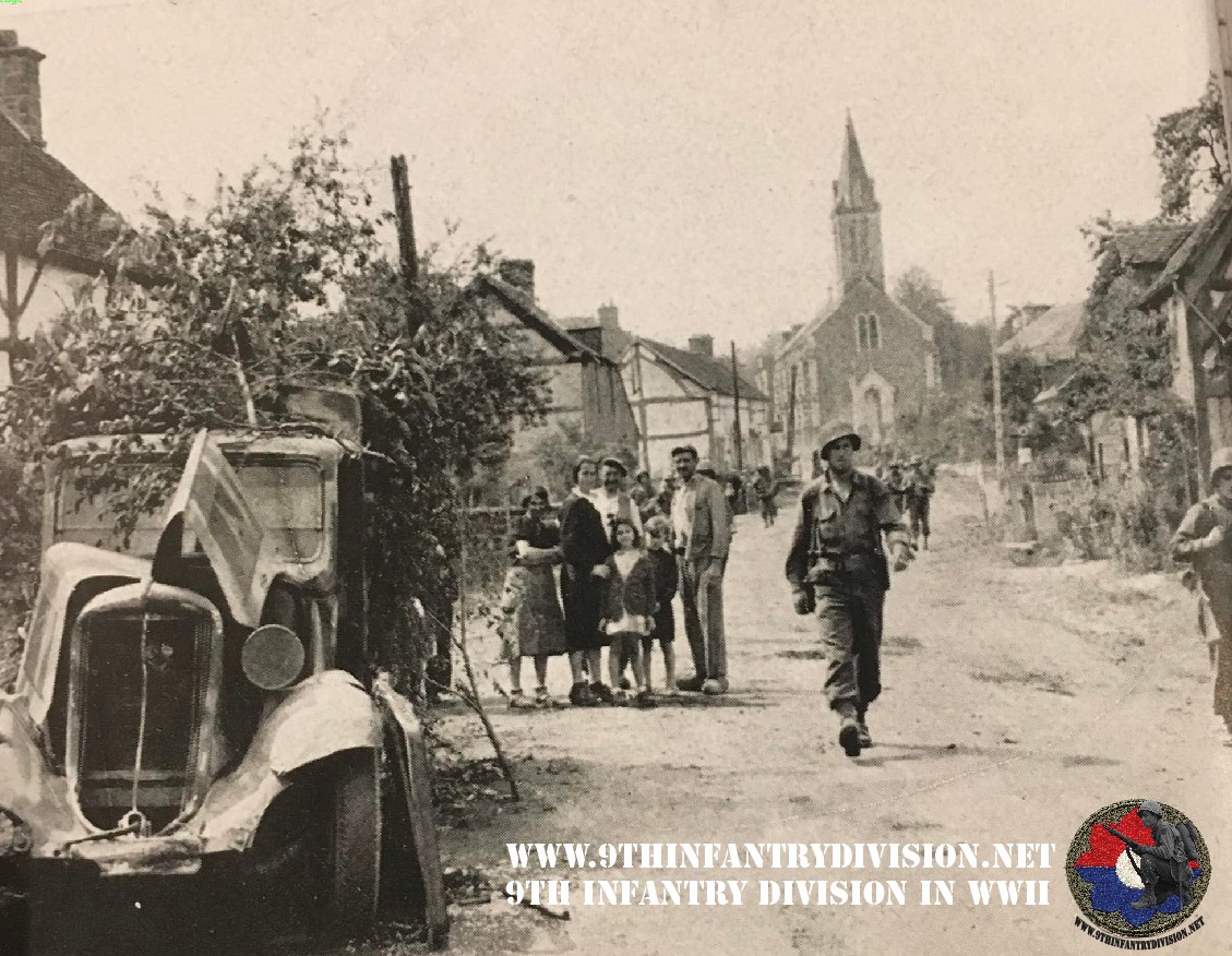 Men of the 39th Infantry Regiment walk through the town of Le Grais in France on the 16th of August, 1944.